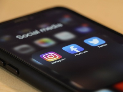 Smartphone mit den App Icons von Instagram, Facebook und Twitter.