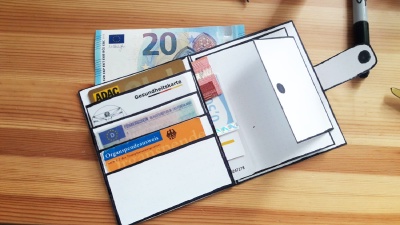 Paper prototype of the perfect wallet for Tom that is filled with some money and cards.